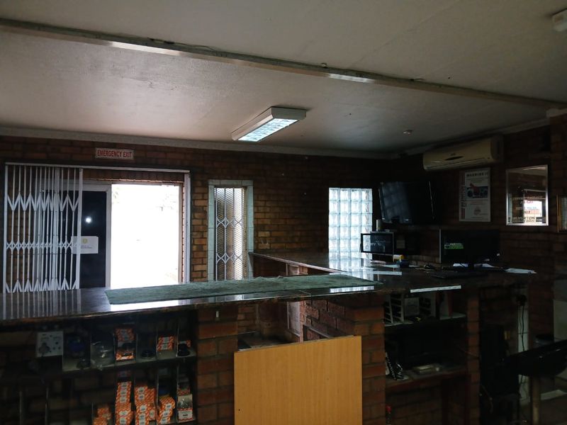 Commercial office space featuring exposed brick walls, a built-in service counter, and security access points.