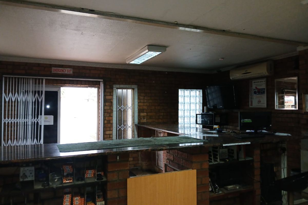 Commercial office space featuring exposed brick walls, a built-in service counter, and security access points.