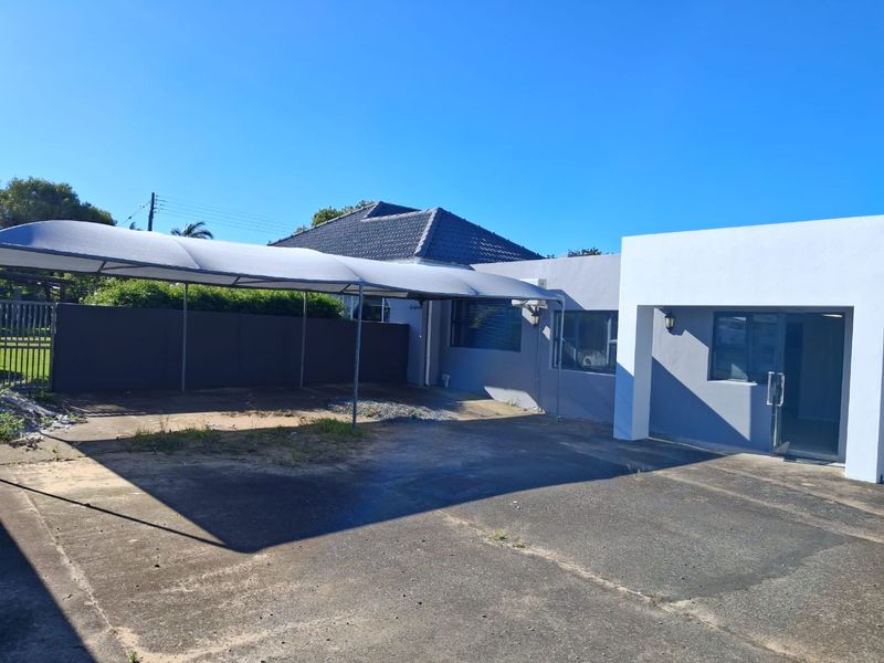 Front exterior view of the office property featuring a concrete driveway, a shade port, and a modern entrance area.