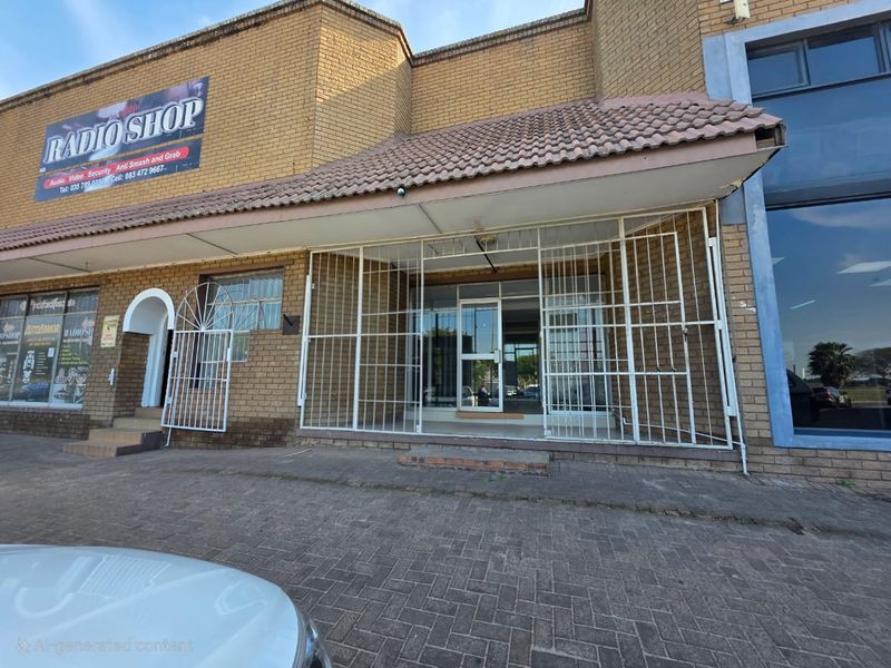 Front exterior view of a commercial retail unit featuring brick facade, tiled roof overhang, and secure metal gate entrance.