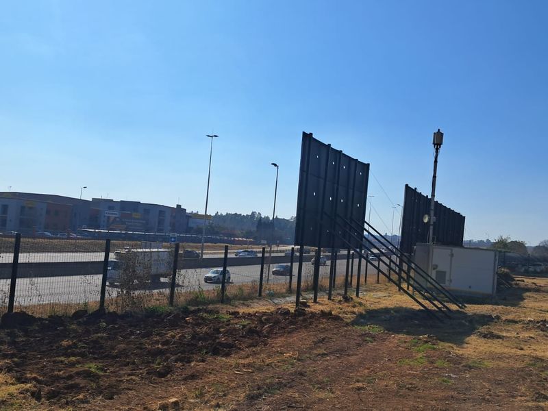 Exterior view of the property boundary featuring large advertising billboards and perimeter fencing adjacent to a major highway.