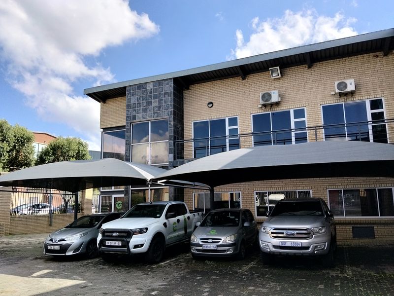 Front elevation of an industrial property featuring face brick construction, aluminum windows, and dedicated shade cloth parking bays.
