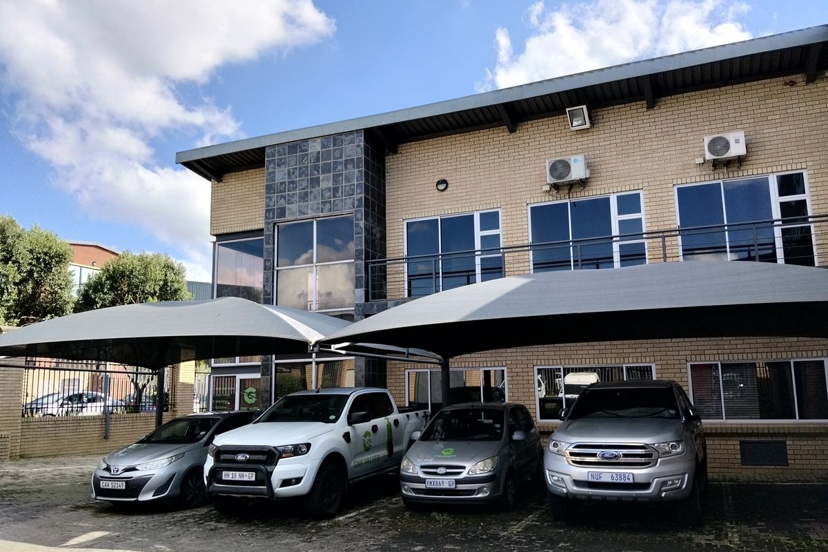 Front elevation of an industrial property featuring face brick construction, aluminum windows, and dedicated shade cloth parking bays.