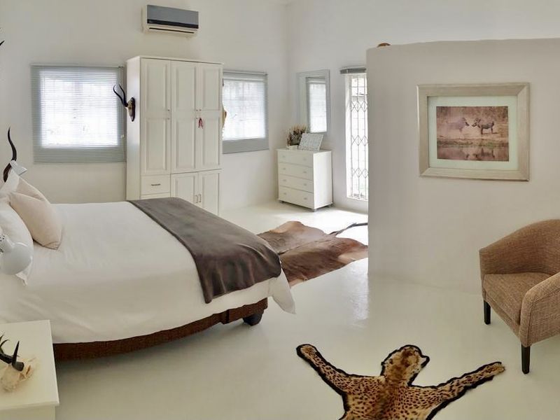 Spacious bedroom featuring a built-in wardrobe, split-system air conditioning, and neutral finishes, offering a bright and comfortable living space.