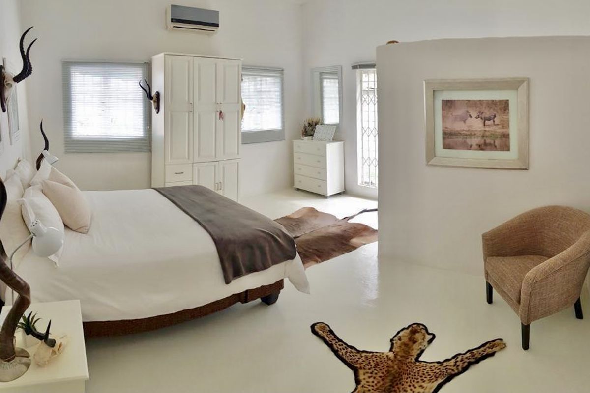 Spacious bedroom featuring a built-in wardrobe, split-system air conditioning, and neutral finishes, offering a bright and comfortable living space.