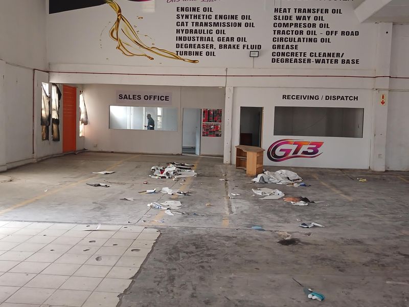 Industrial warehouse space featuring a designated sales office, receiving and dispatch area, and large wall-mounted branding signage.