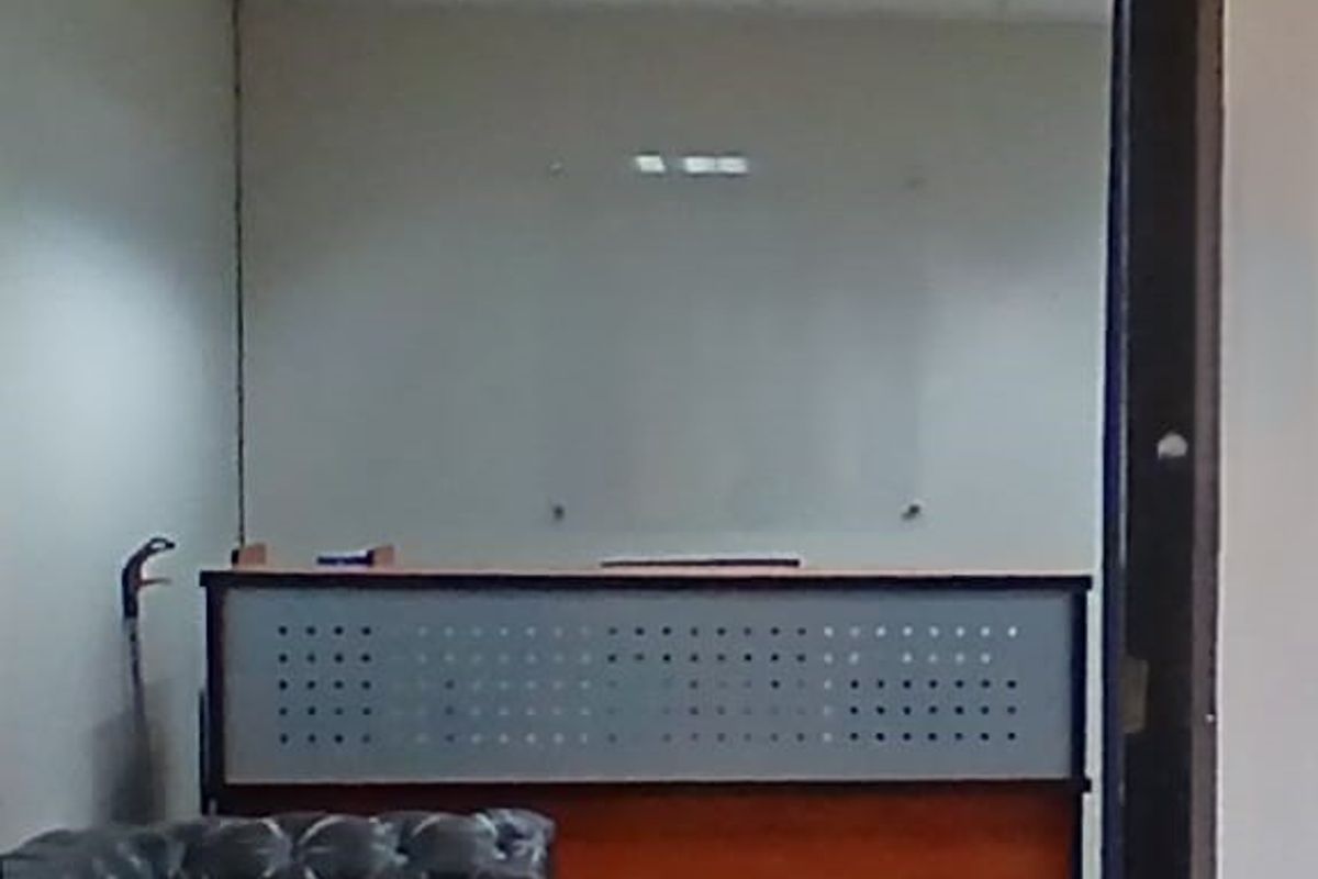 A functional office space featuring a built-in reception desk and a wall-mounted glass whiteboard, suitable for professional use.
