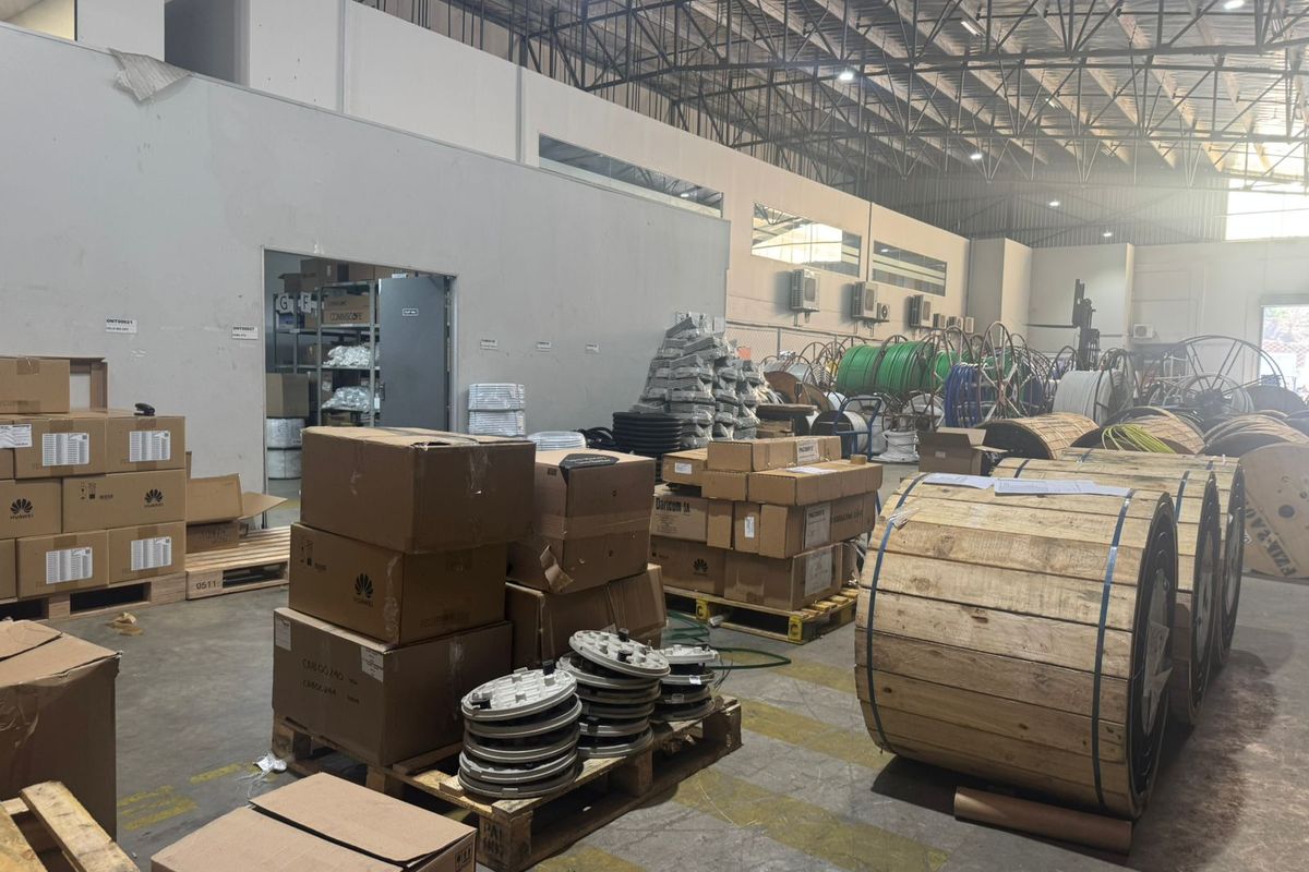 Spacious industrial warehouse facility featuring high ceilings with exposed steel trusses, concrete flooring, and integrated partitioned office space.