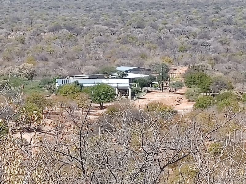 An elevated aerial view of a farm property nestled within a natural bushveld landscape.