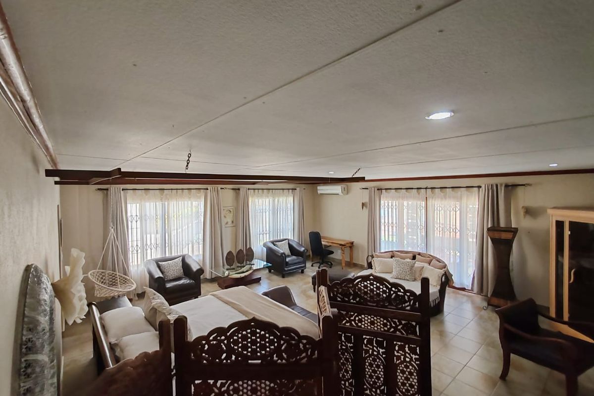 Spacious bedroom featuring tiled flooring, recessed lighting, and a split-system air conditioner, with large windows fitted with security gates.