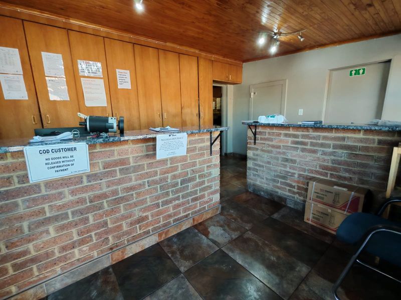 Industrial reception area featuring a brick counter with granite top, built-in wooden cabinetry, and tiled flooring.