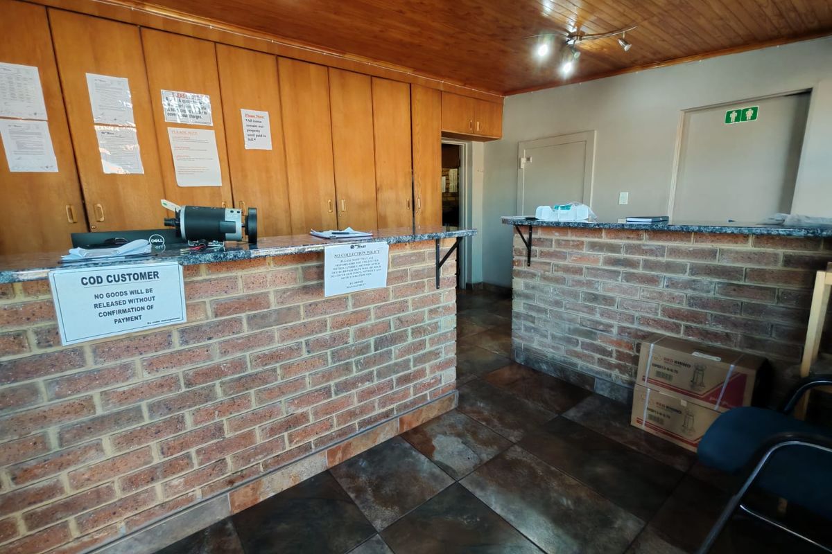 Industrial reception area featuring a brick counter with granite top, built-in wooden cabinetry, and tiled flooring.