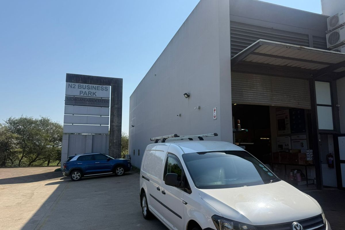 Front exterior view of an industrial unit in N2 Business Park, featuring a large roller shutter door and concrete driveway access.