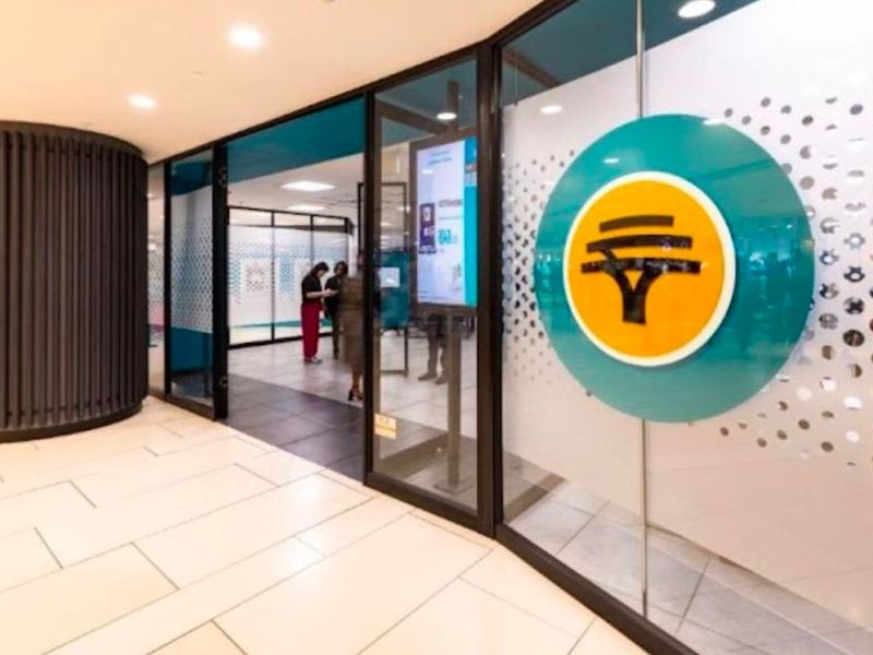 Modern retail entrance featuring a glass storefront, professional branding, recessed lighting, and high-quality tiled flooring in a well-maintained commercial space.