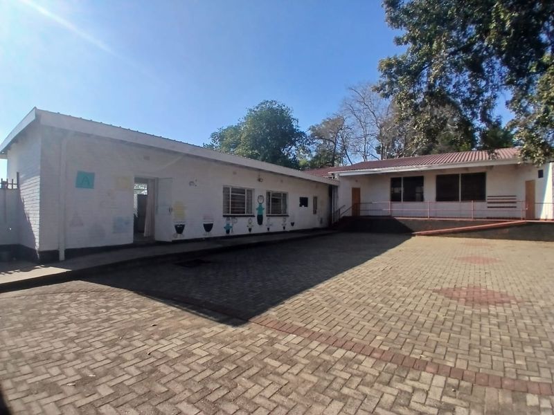 A view of the rear exterior courtyard featuring paved ground, brick building facades, and metal window frames.
