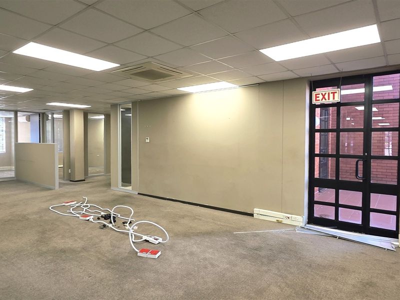 An open-plan office space featuring suspended ceilings, recessed lighting, integrated air conditioning, and glass partitions, currently vacant and ready for fit-out.