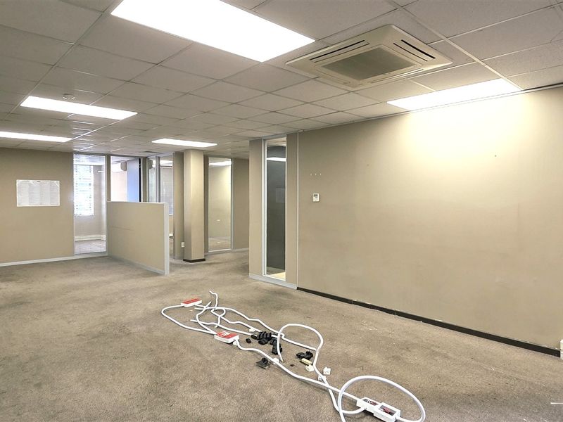 An open-plan office space featuring suspended ceilings, recessed lighting, ducted air conditioning, and glass partitioning, providing a versatile layout for professional use.