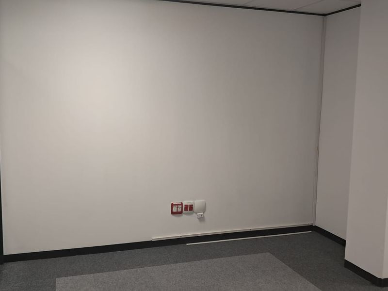 A clean, empty office space featuring neutral walls, carpet flooring, and a modern glass partition wall, ready for professional fit-out.
