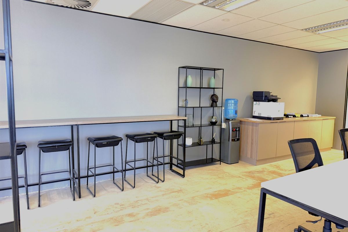 A functional office space featuring a suspended ceiling, recessed lighting, and built-in cabinetry with a dedicated workspace area.