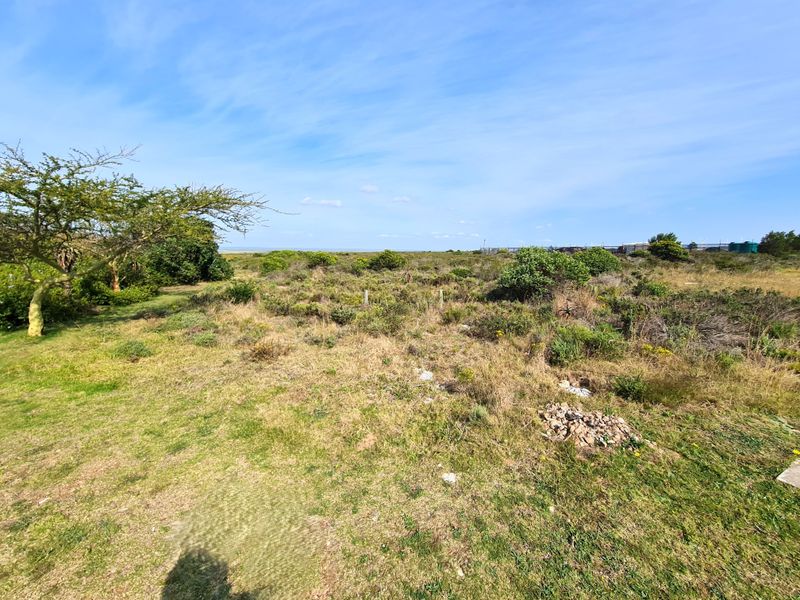 A view of the vacant commercial land featuring natural vegetation and open space, suitable for future development.