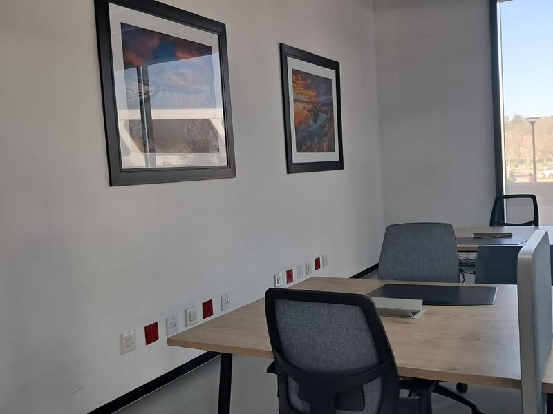 A modern, well-lit office space featuring large windows, integrated electrical and data points, and a clean, professional aesthetic.