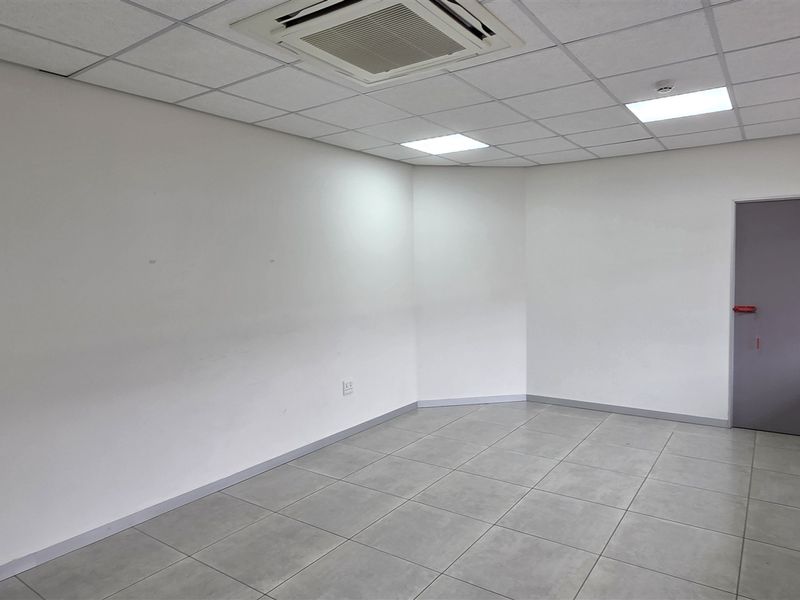 A bright, vacant office space featuring tiled flooring, a suspended ceiling with recessed lighting, and integrated air conditioning, ready for professional fit-out.