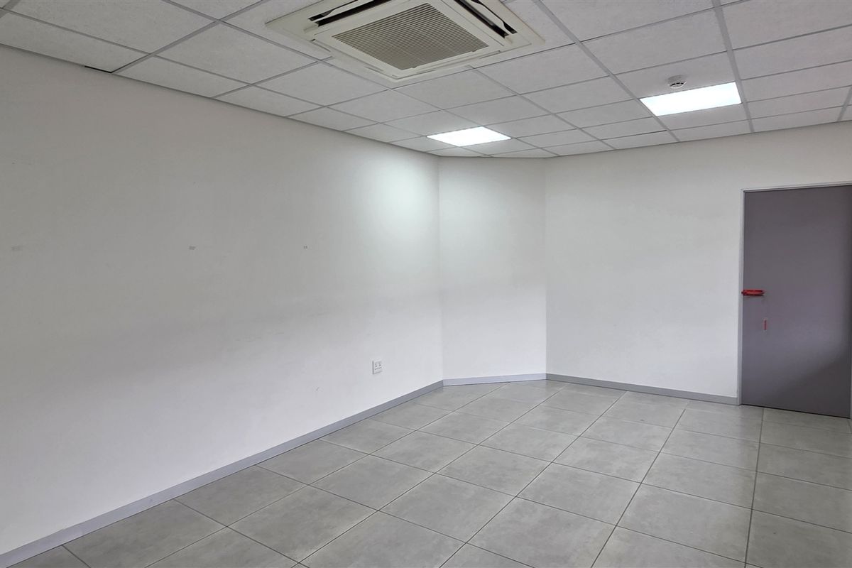 A bright, vacant office space featuring tiled flooring, a suspended ceiling with recessed lighting, and integrated air conditioning, ready for professional fit-out.