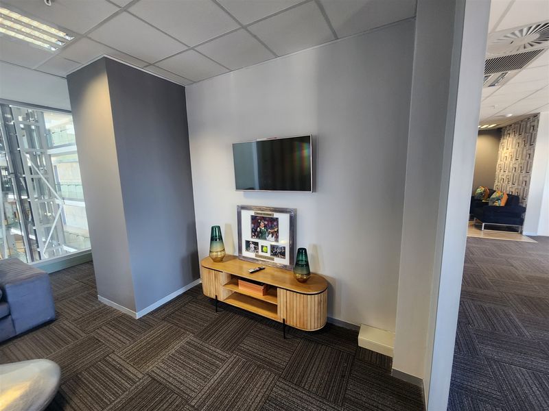 A modern office space featuring carpet tiles, a suspended ceiling with recessed lighting, and integrated air conditioning, providing a professional and functional work environment.
