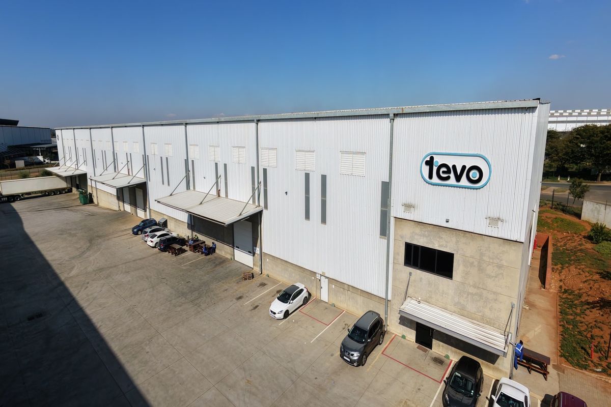 Aerial view of a large industrial warehouse facility featuring multiple loading bays, metal cladding, and a paved yard area.