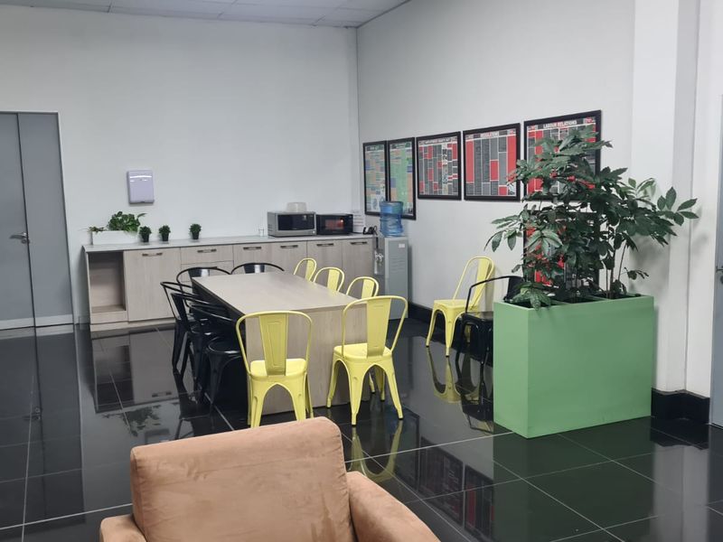 Open plan industrial office space featuring tiled flooring, built-in cabinetry, and functional workspace area.