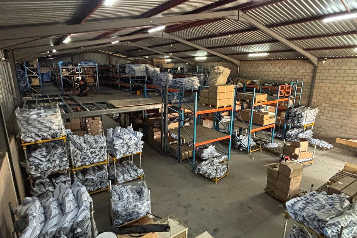 Spacious industrial warehouse featuring a steel portal frame, mezzanine level, and extensive integrated racking systems suitable for storage or distribution operations.