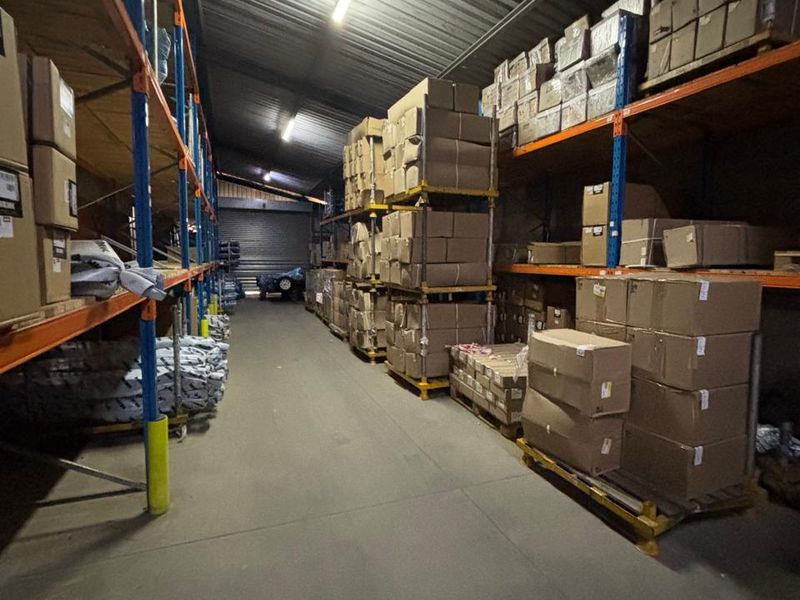 Industrial warehouse space featuring high-capacity steel racking, concrete flooring, and overhead fluorescent lighting, suitable for storage or logistics operations.