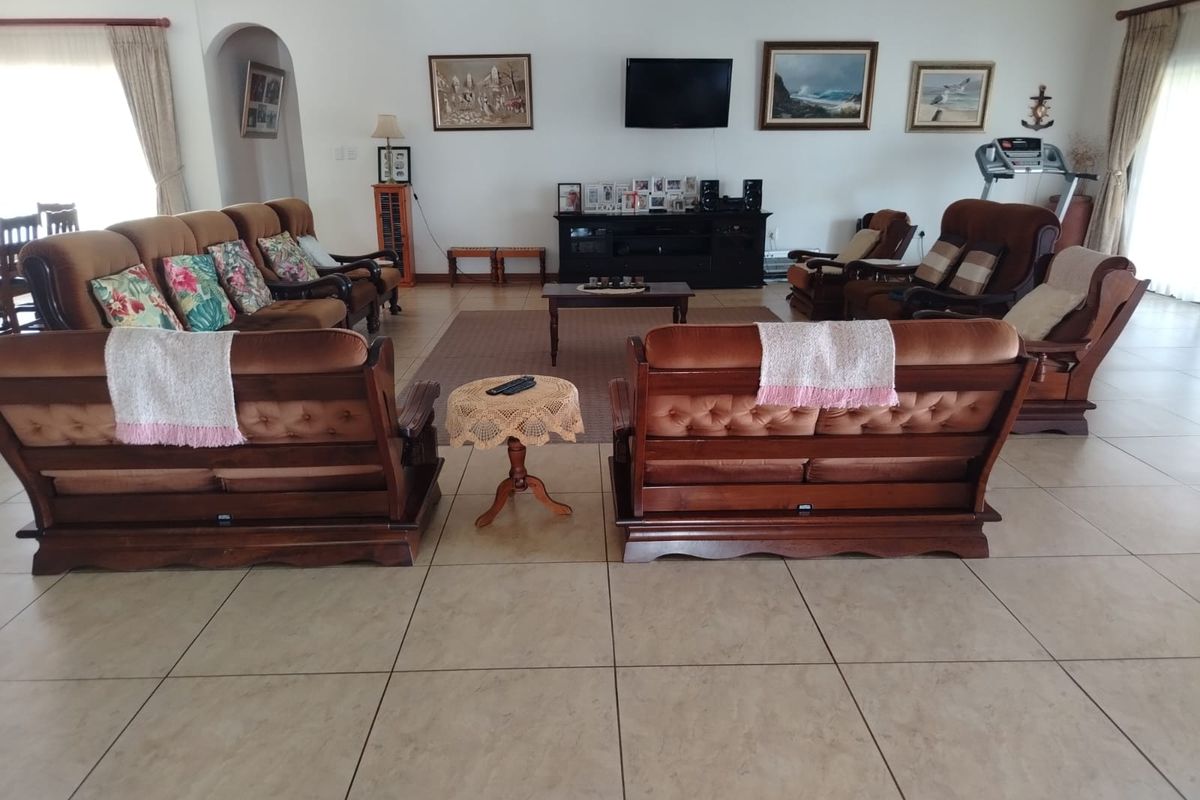 Spacious living room featuring neutral ceramic tile flooring and an arched entryway, providing a comfortable and functional layout for family relaxation.