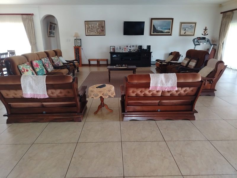 Spacious living room featuring neutral ceramic tile flooring and an arched entryway, providing a comfortable and functional layout for family relaxation.