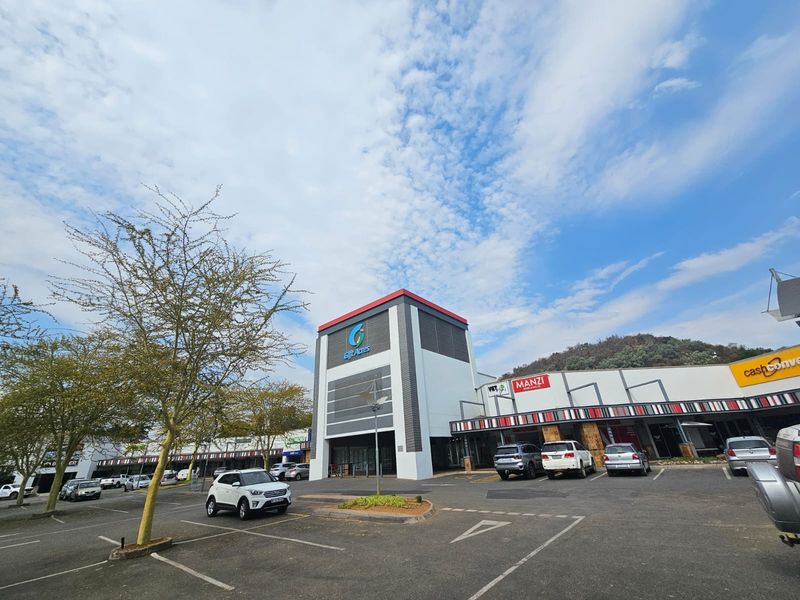 Exterior view of the Gift Acres retail center featuring a paved parking area and modern commercial building facade.