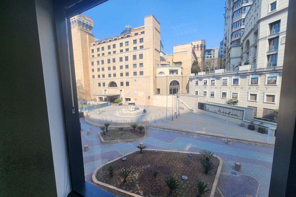 A clear view of the surrounding urban plaza and architectural buildings from an office window.