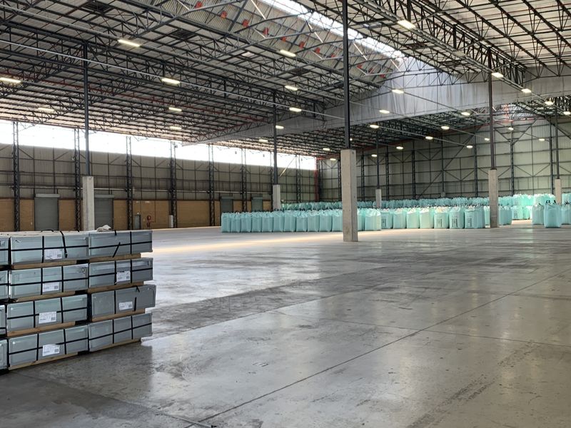 Spacious industrial warehouse featuring high-clearance steel truss roofing, polished concrete floors, and high-bay lighting, suitable for large-scale storage or manufacturing operations.