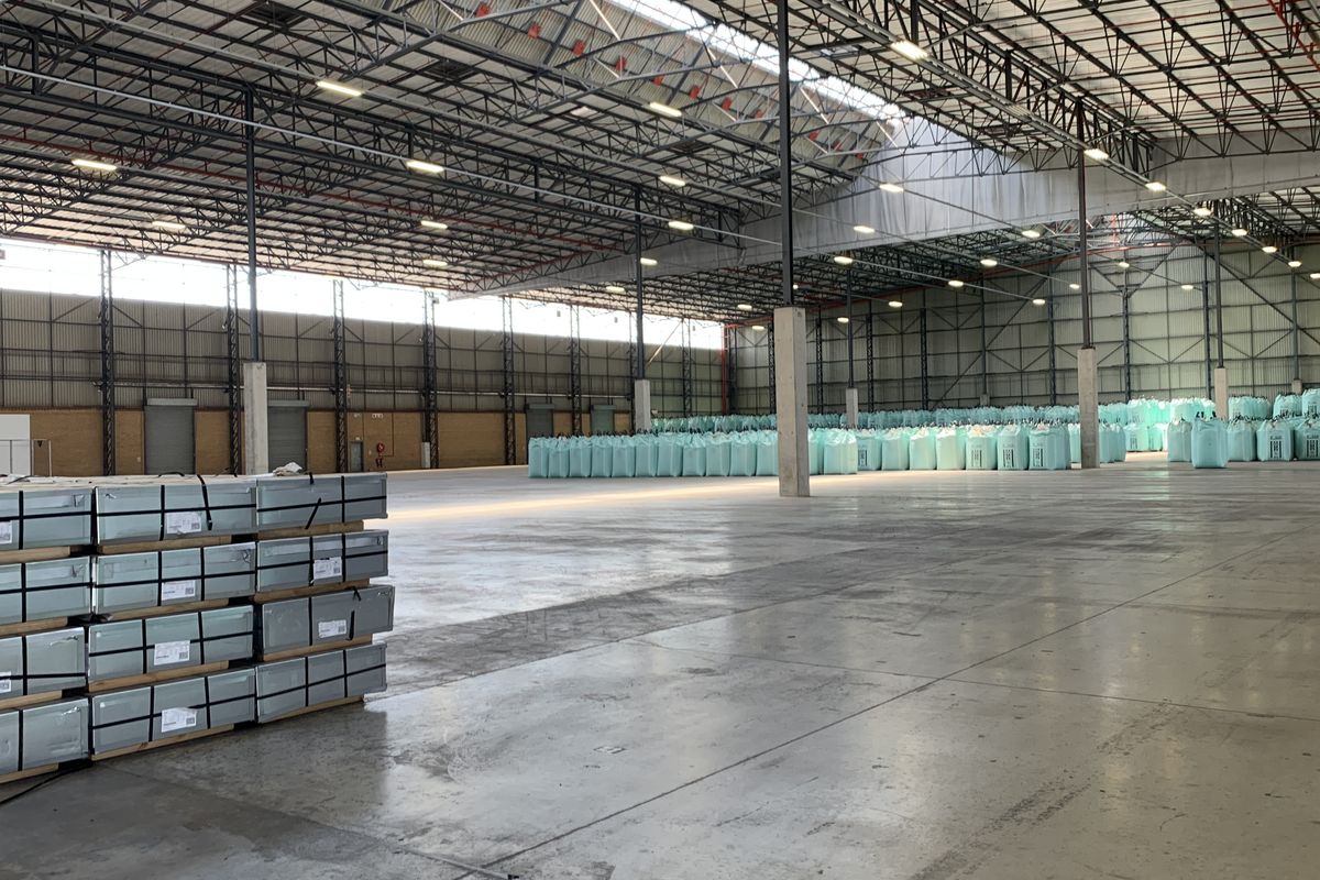 Spacious industrial warehouse featuring high-clearance steel truss roofing, polished concrete floors, and high-bay lighting, suitable for large-scale storage or manufacturing operations.