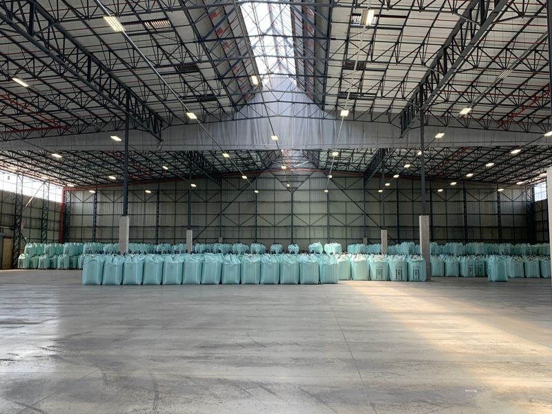 Spacious industrial warehouse featuring high-clearance steel truss roofing, integrated skylights, fire sprinkler systems, and durable concrete flooring.