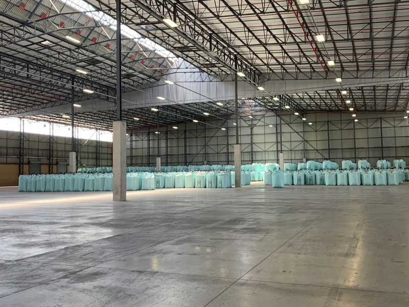 Spacious industrial warehouse featuring high-clearance steel truss roofing, polished concrete flooring, and integrated fire sprinkler systems, suitable for large-scale storage or logistics operations.