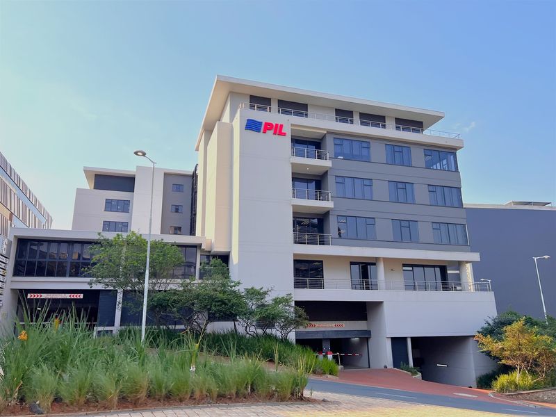 Modern multi-story office building featuring balconies, secure underground parking access, and well-maintained exterior landscaping.