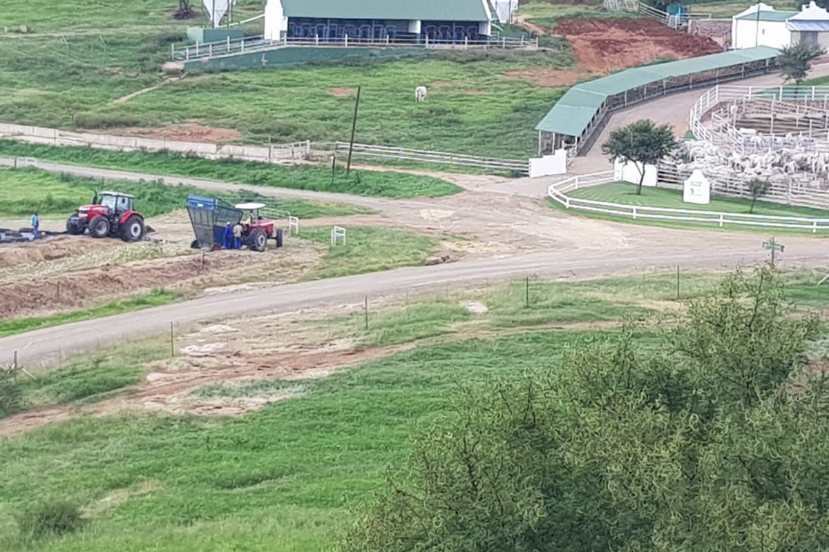 Aerial view of a working farm property featuring livestock enclosures, gravel access roads, and agricultural infrastructure.