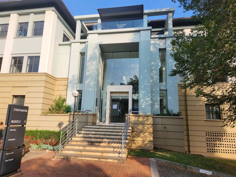 Front elevation of a modern office building featuring a prominent glass entrance, stone staircase, and professional architectural design.