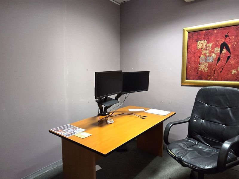 A compact office space featuring neutral walls and recessed lighting, suitable for a private workspace or small business administrative area.