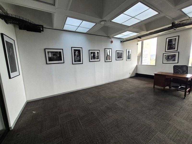 A professional office space featuring a coffered ceiling with recessed lighting, carpet tile flooring, and exposed cable management systems.