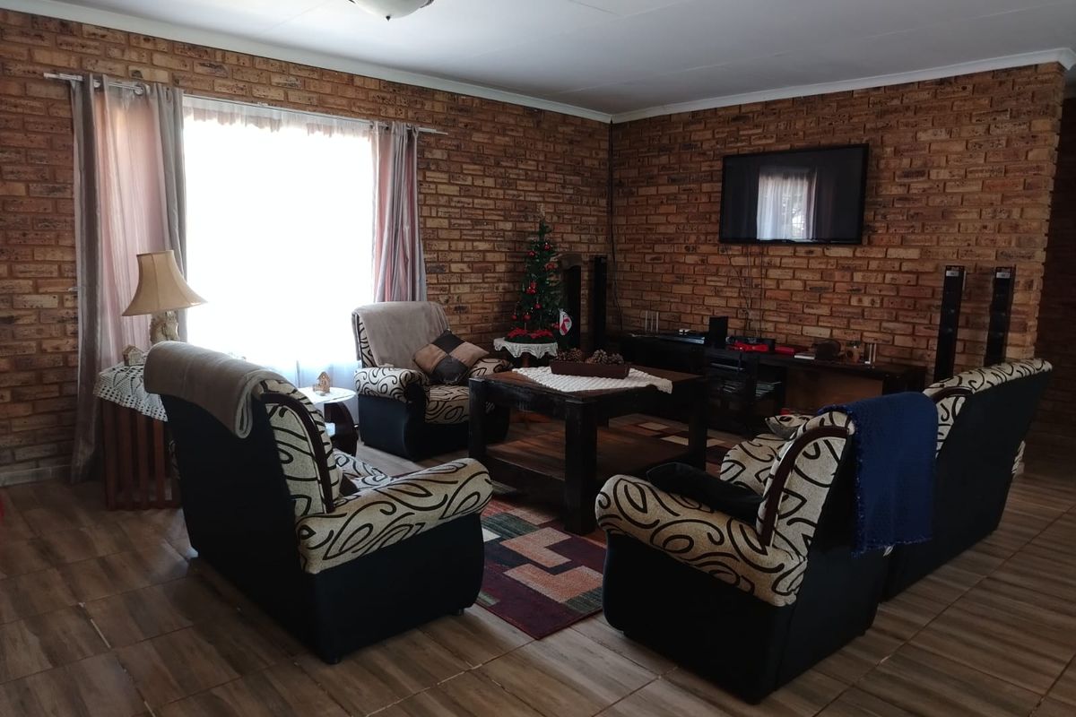 A cozy living room featuring rustic exposed brick walls and durable tiled flooring, providing a warm and traditional atmosphere.