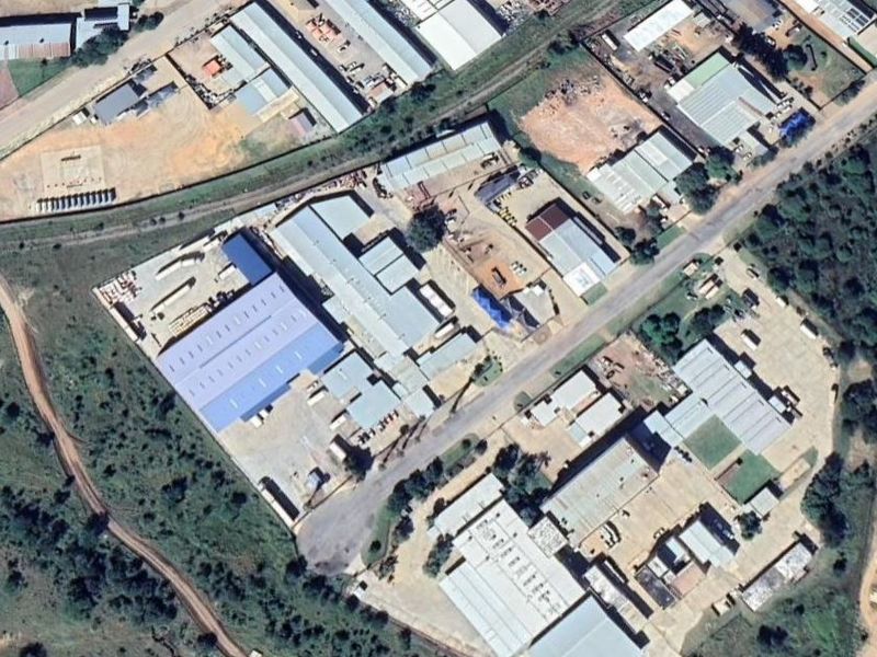 Aerial view of an industrial property complex featuring multiple warehouse buildings, metal roofing, and extensive paved yard space for logistics and operations.