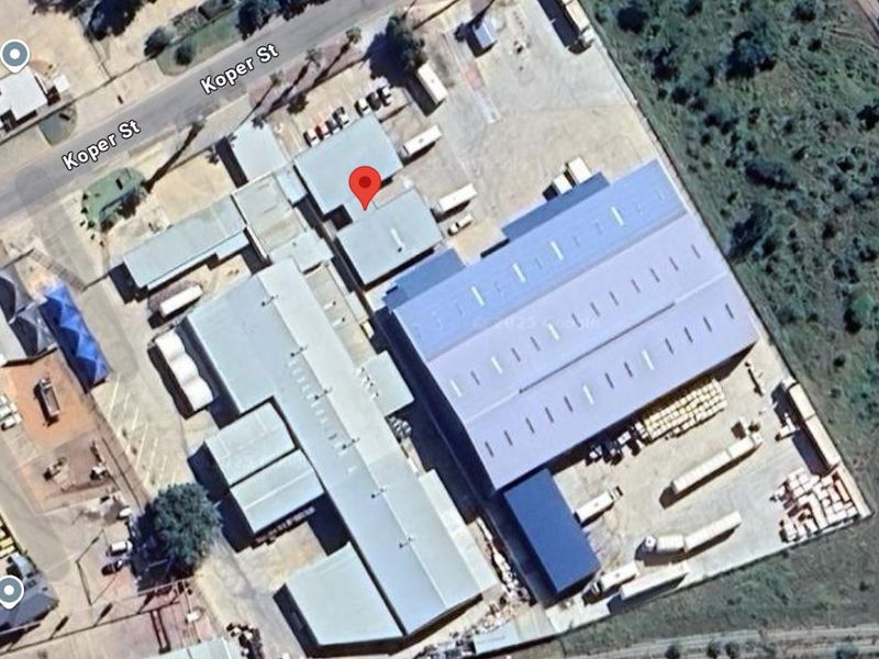 Aerial view of an industrial property complex featuring multiple warehouse structures, metal roofing, and extensive paved yard space for logistics and operations.