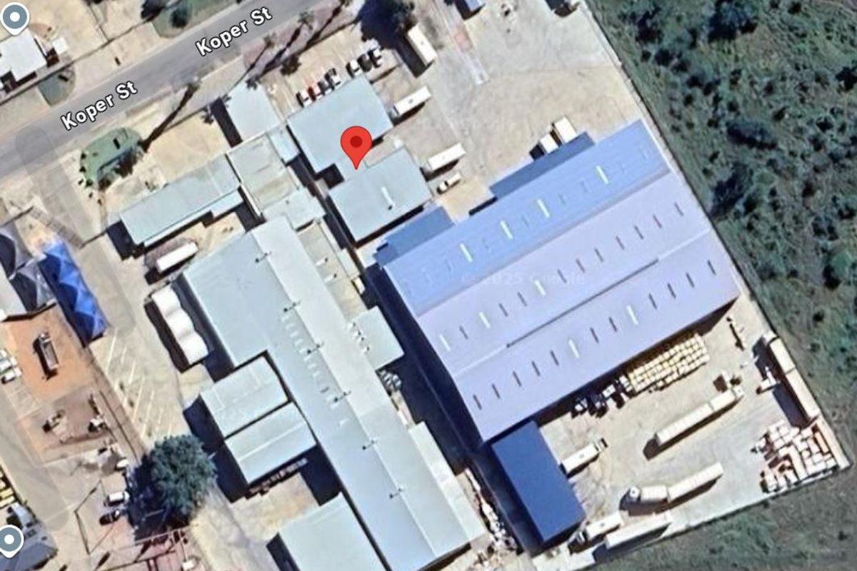 Aerial view of an industrial property complex featuring multiple warehouse structures, metal roofing, and extensive paved yard space for logistics and operations.