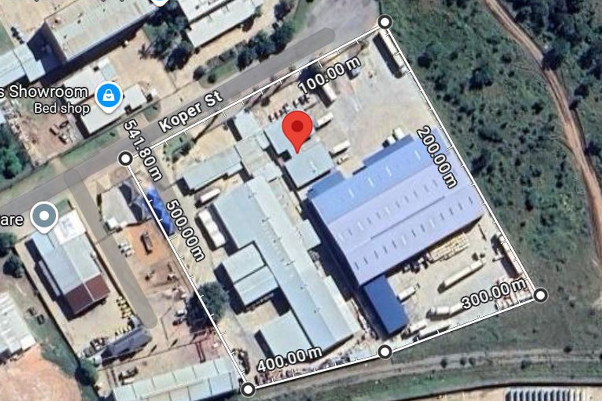 Aerial view of an industrial property featuring multiple warehouse structures and a large yard area with perimeter access.